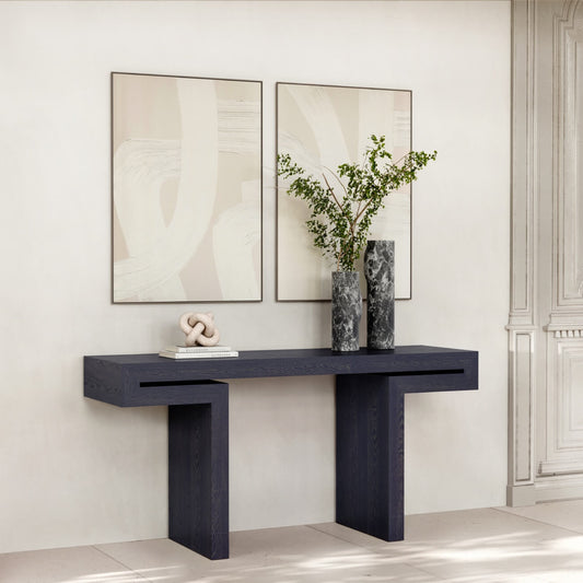 Modern black console table with abstract art, marble vases with greenery, minimalist decor against white wall