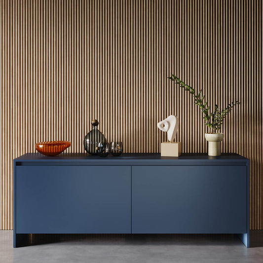Modern navy blue credenza with decorative objects against slatted wood wall, minimalist contemporary styling