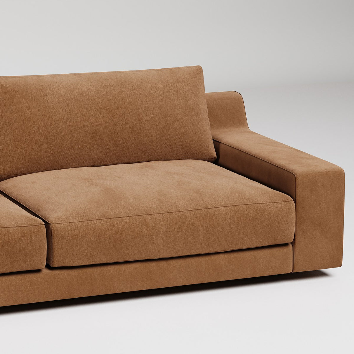 Modern brown suede sofa with clean lines and thick cushions against white background
