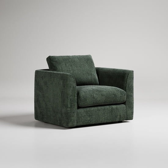 Modern forest green velvet armchair with square arms and cushioned seat against neutral gray backdrop
