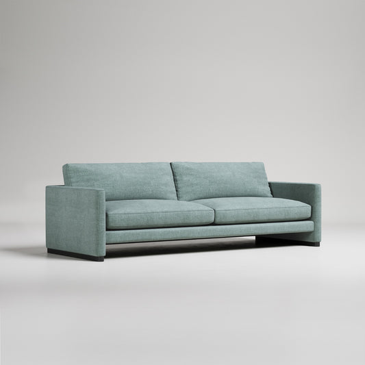 Modern mint green sofa with clean lines and wide arms on gray background, studio product photography
