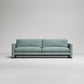 Modern sage green upholstered sofa with clean lines and square arms against neutral gray background
