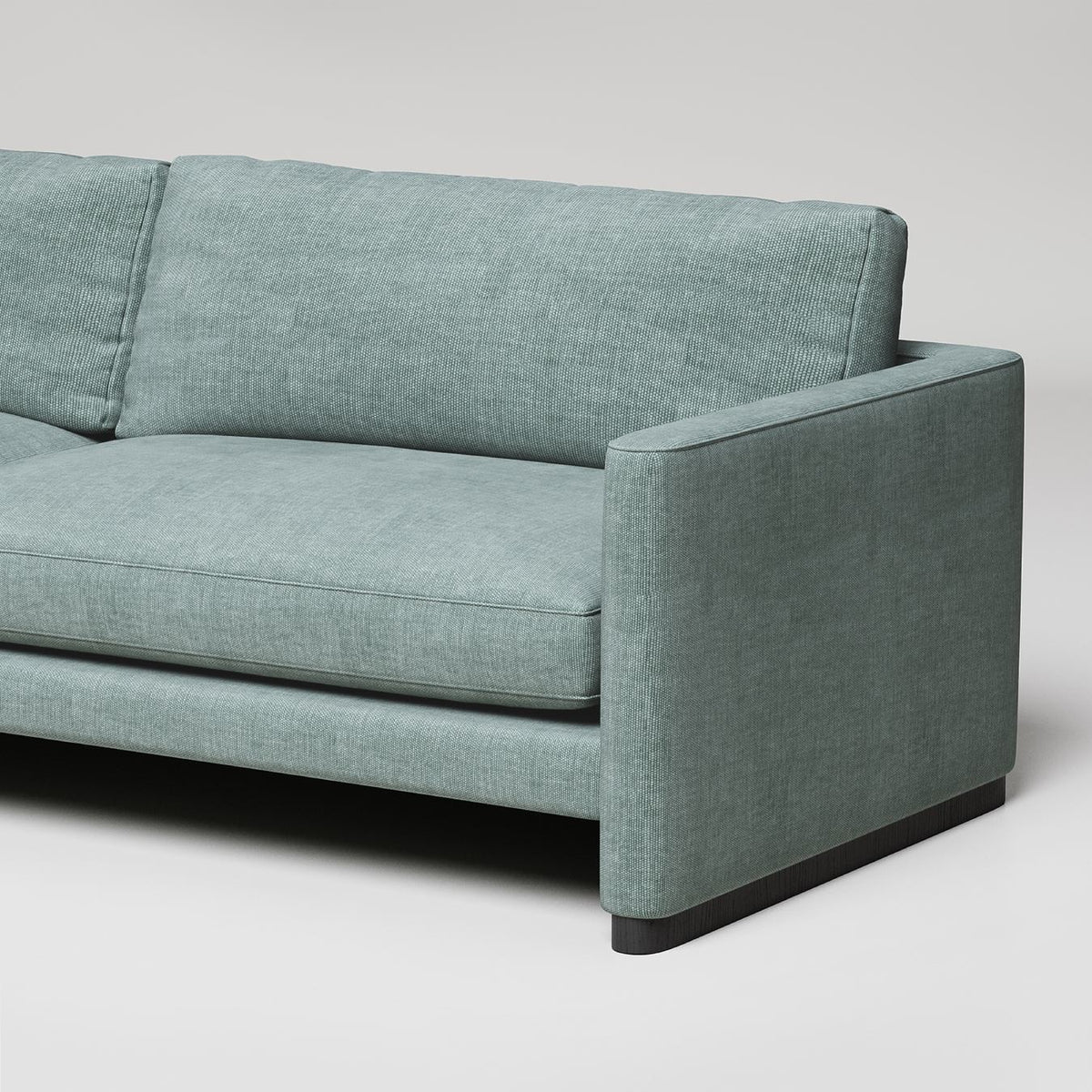 Modern mint green sofa with clean lines, dark wood base, and textured upholstery against white background
