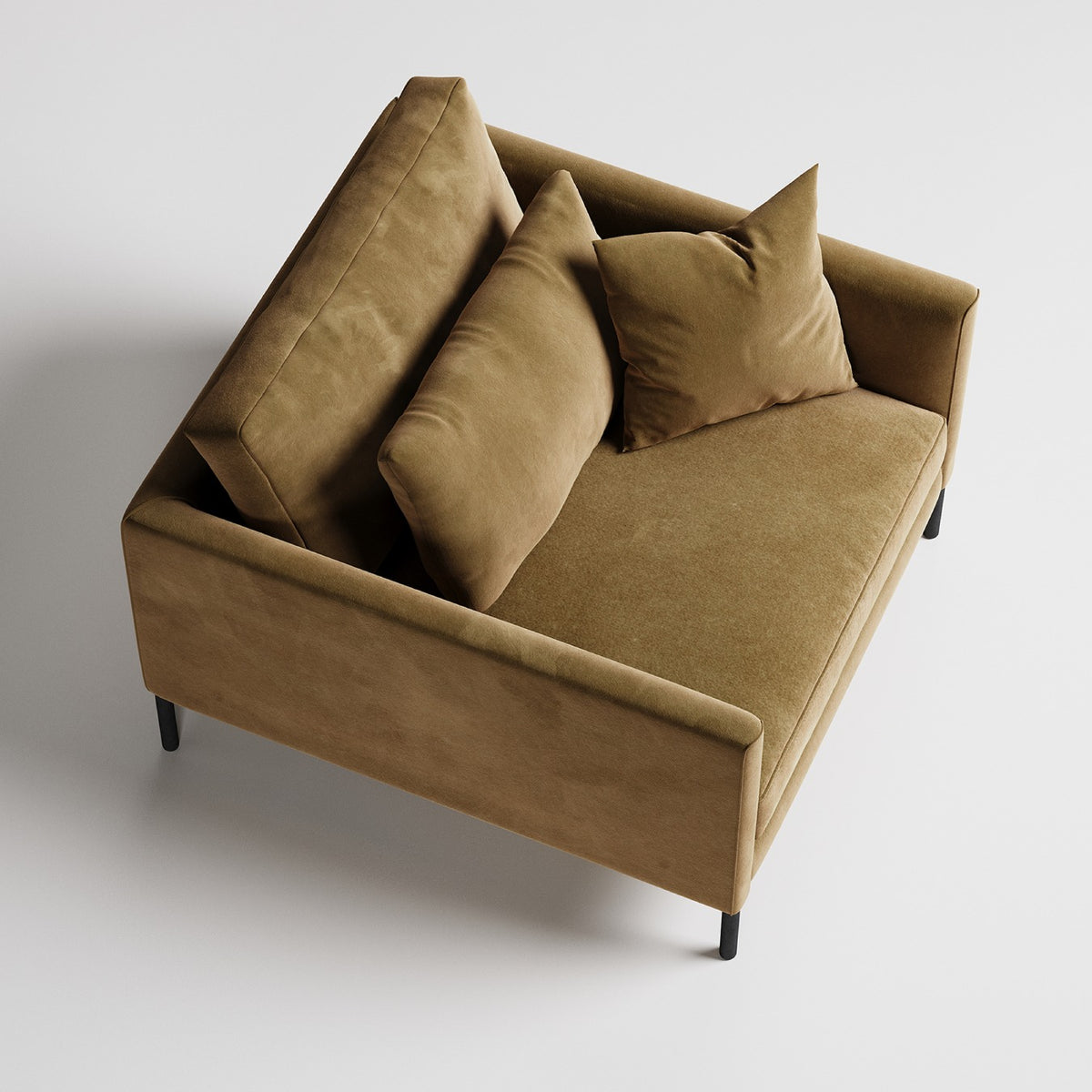 Modern tan velvet armchair with high back and throw pillows on black metal legs, viewed from above
