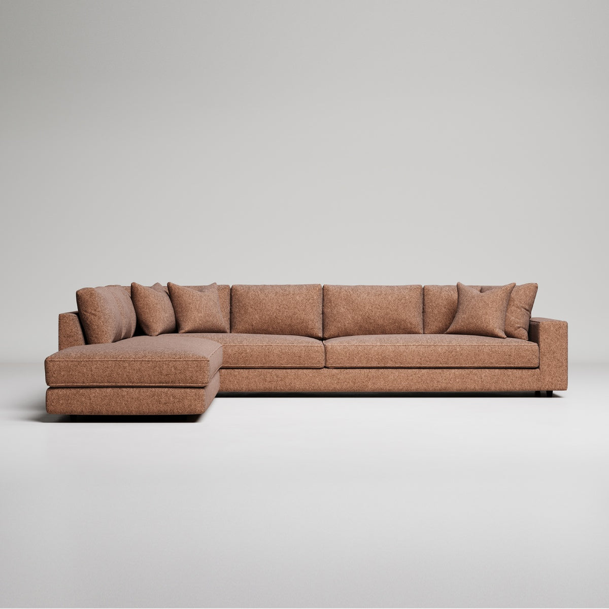 Modern brown L-shaped sectional sofa with chaise lounge and throw pillows against grey background
