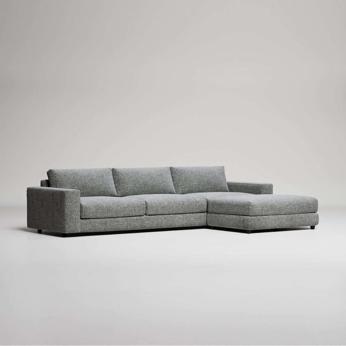 Modern grey L-shaped sectional sofa with chaise lounge on white background, minimalist furniture design
