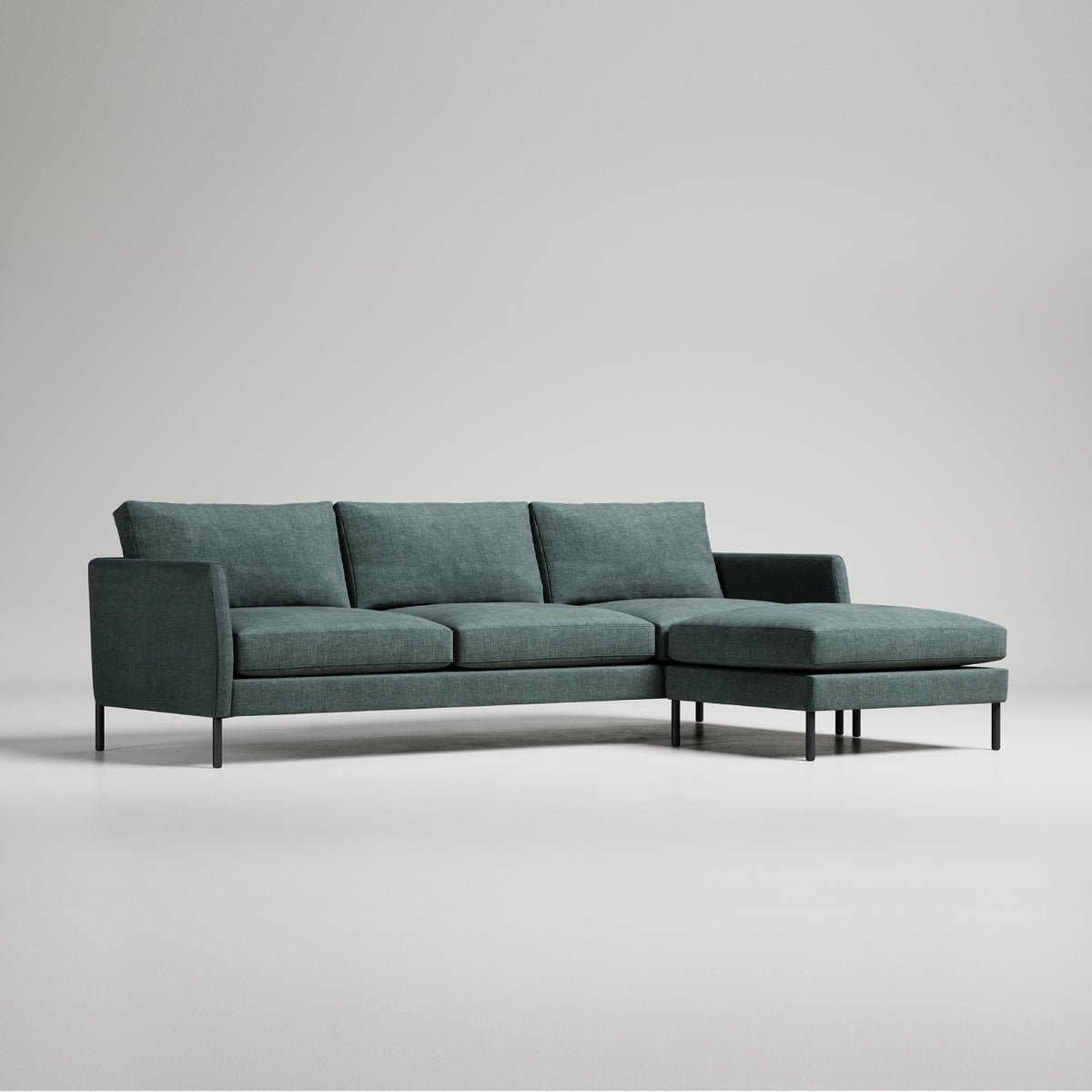 Modern green sectional sofa with chaise lounge, black metal legs, against white background, minimalist design
