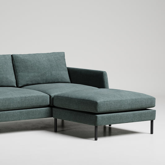Sleek modern green sectional sofa with chaise lounge on black metal legs against white backdrop
