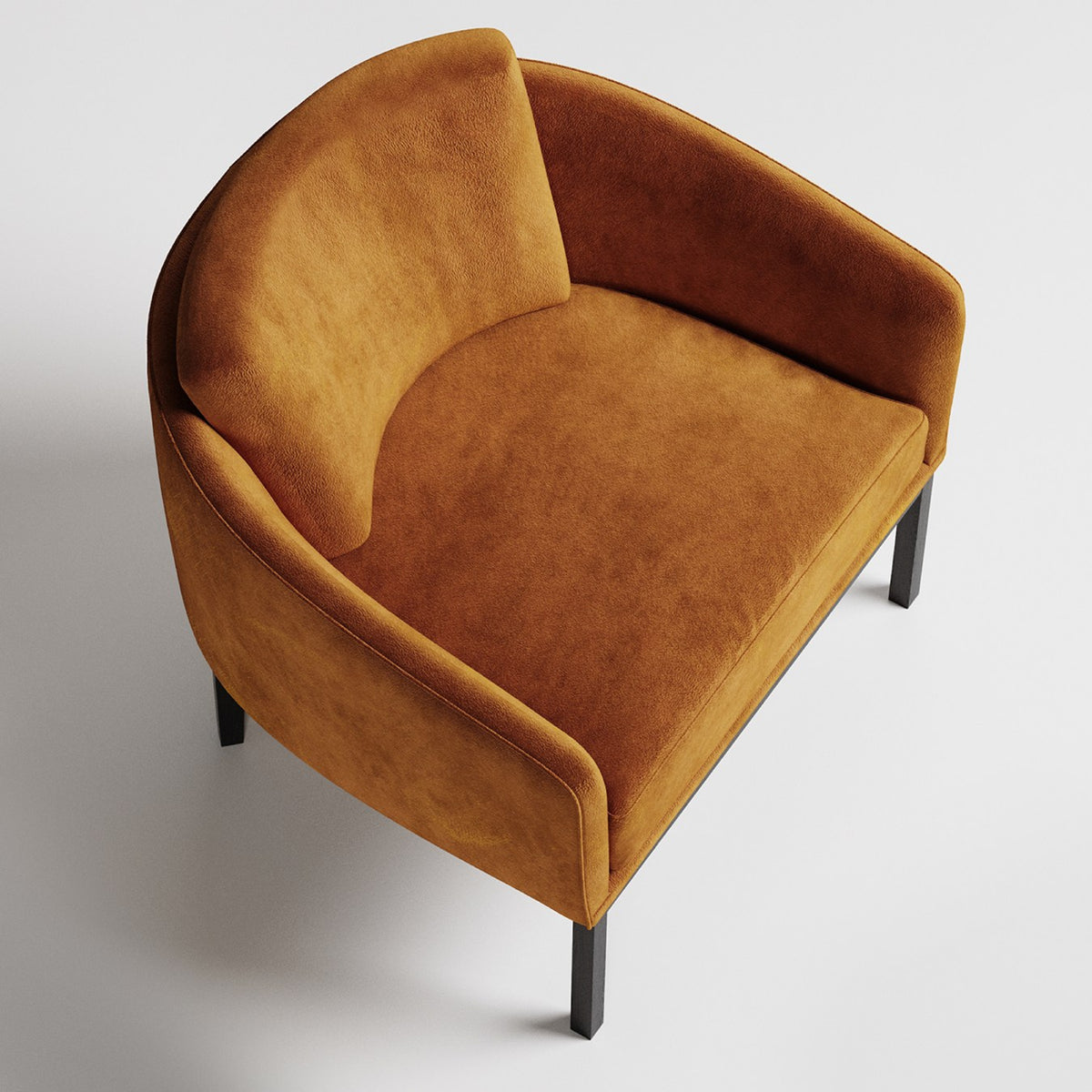Modern curved armchair in caramel velvet upholstery with black metal legs, viewed from above angle
