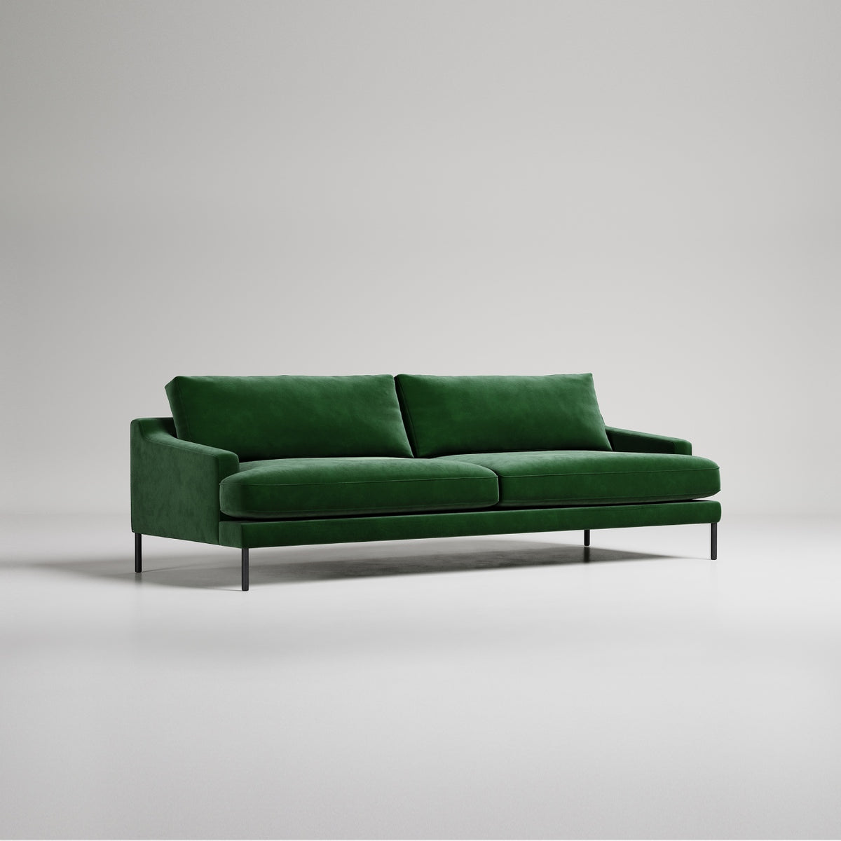 Modern emerald green velvet sofa with black metal legs on white background, studio product photography
