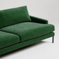 Modern emerald green velvet sofa with black metal legs on white background, minimalist design detail shot
