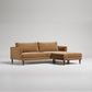 Modern brown sectional sofa with chaise lounge, tapered black legs, clean lines against white background
