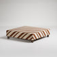 Patterned rectangular ottoman with fabric upholstery on white background, modern minimalist design