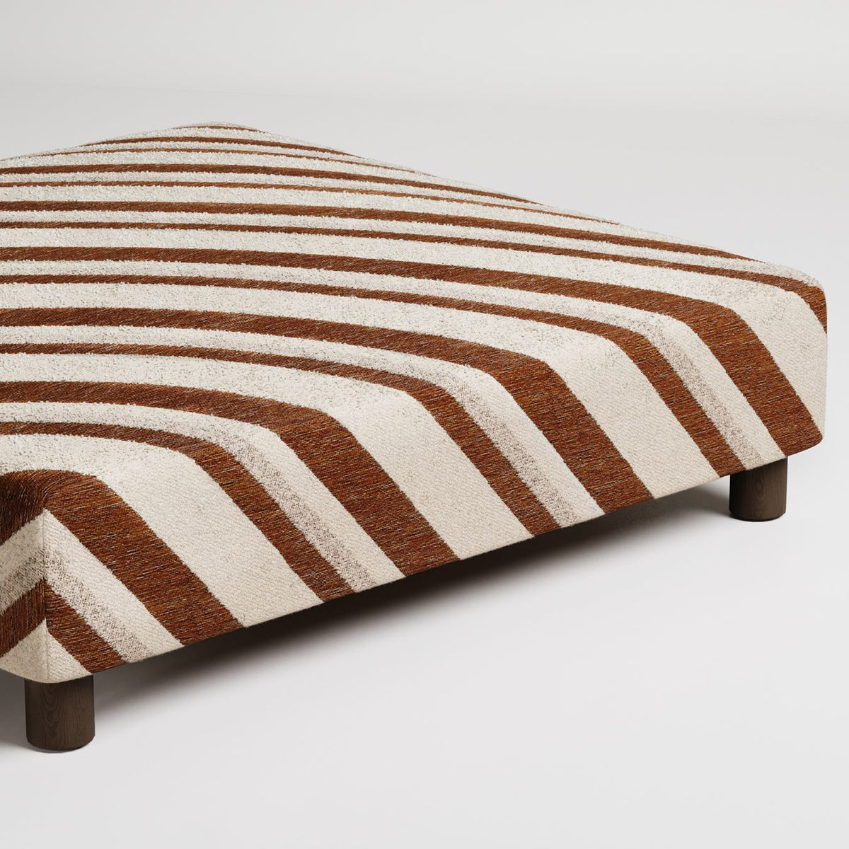 patterned upholstered ottoman shown against white background in studio lighting