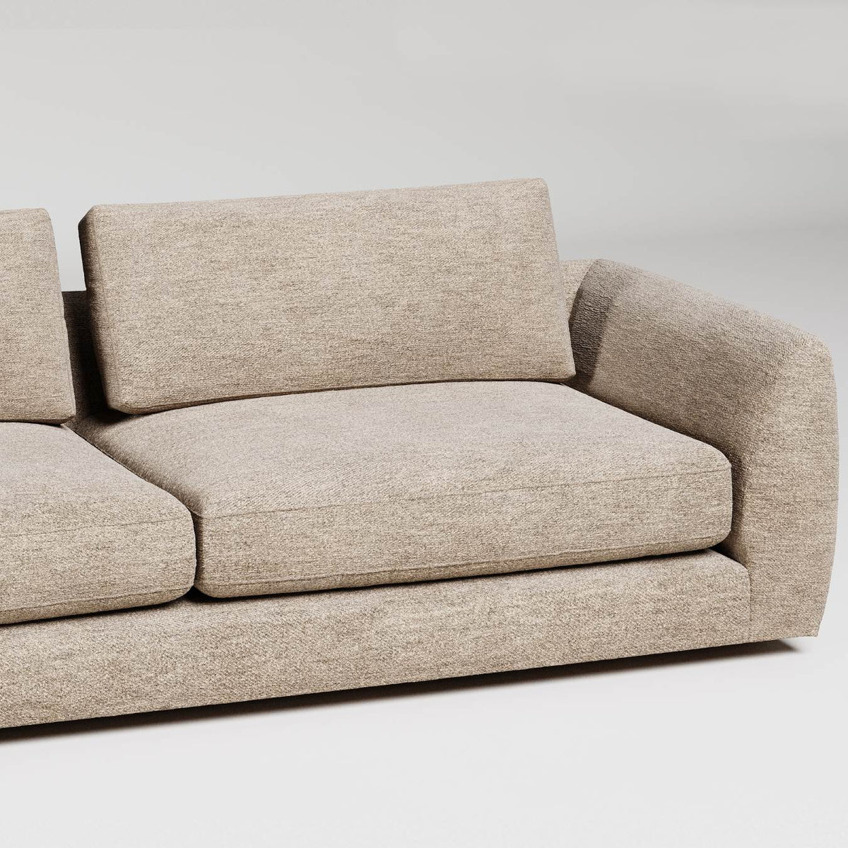 Modern beige sofa with curved arms and back detail against white background, studio product photography