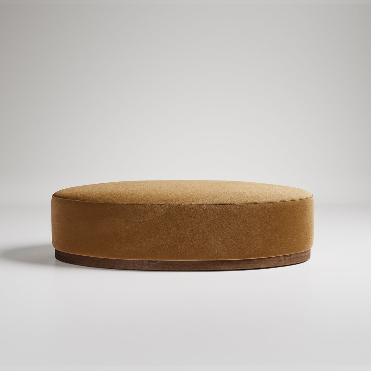 Large round camel-colored velvet ottoman with dark wood base, photographed on white background
