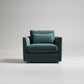 Teal velvet modern armchair with clean lines and matching throw pillow against light gray backdrop
