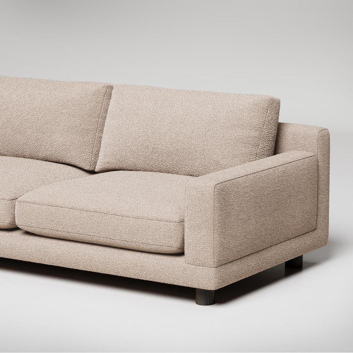 Modern beige textured fabric sofa with clean lines and dark wooden feet against white background
