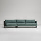 Modern sage green sectional sofa with clean lines and tapered legs on light gray background, studio shot
