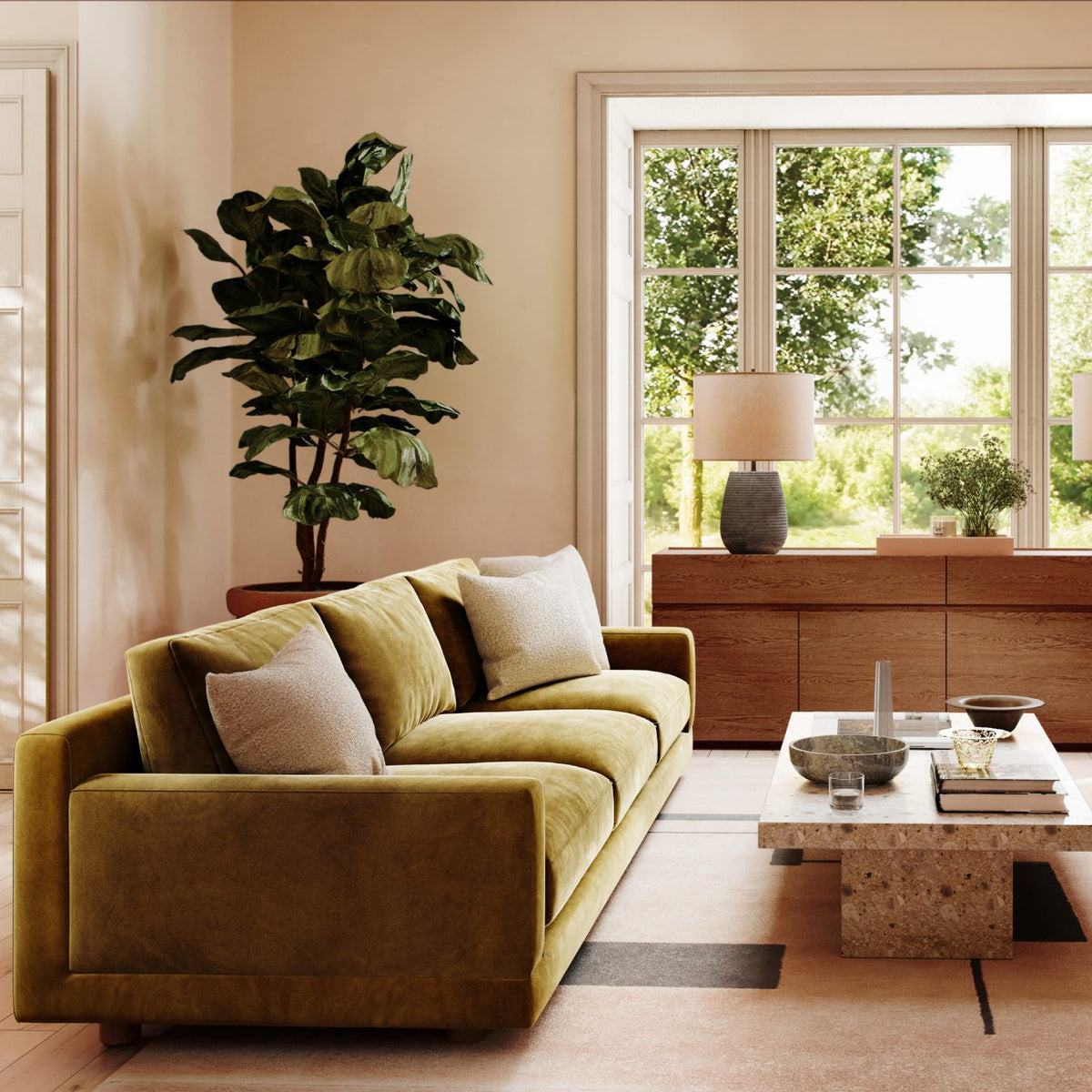 Modern living room with olive velvet sofa, fiddle leaf fig plant, stone coffee table, and bright window view
