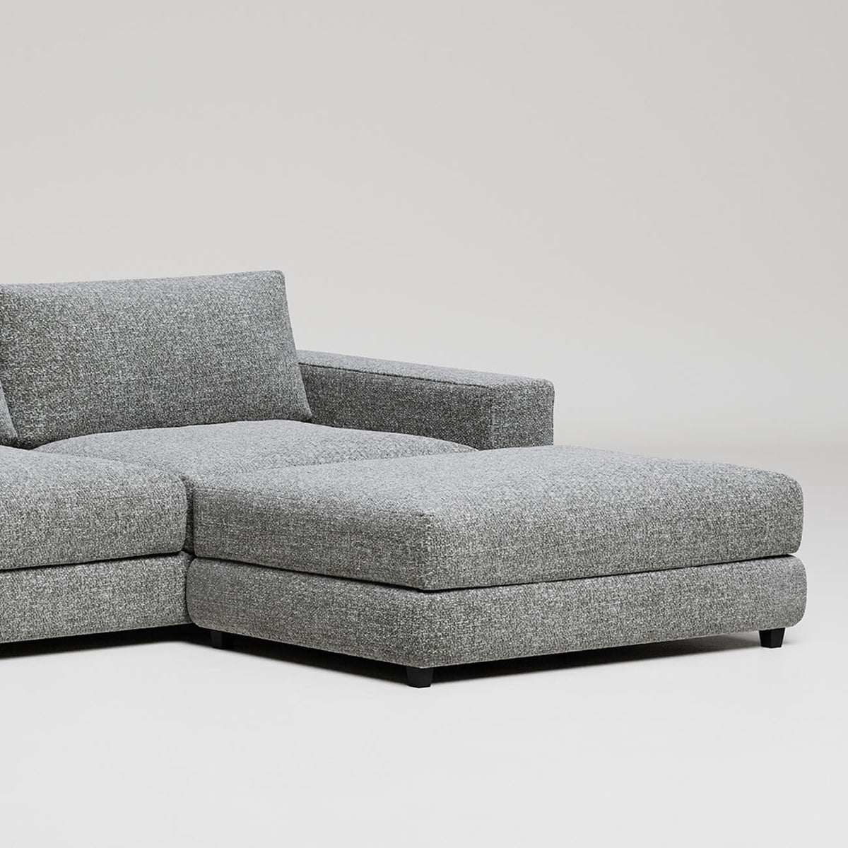 Modern gray L-shaped sectional sofa with chaise lounge on white background, clean minimalist furniture design
