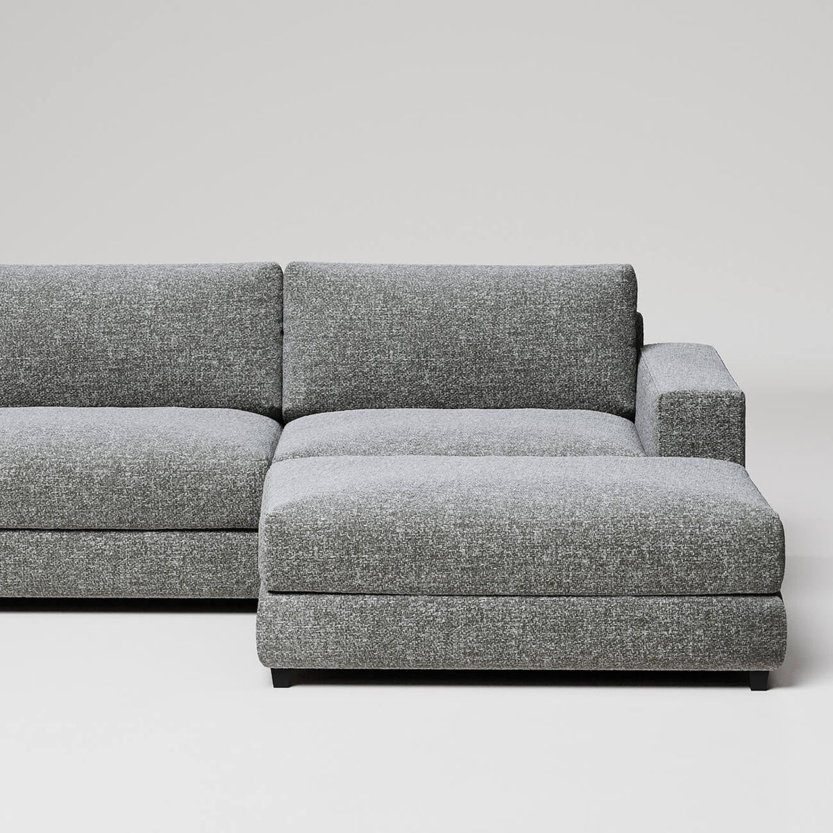 Modern gray L-shaped sectional sofa with chaise lounge on white background, clean minimalist design
