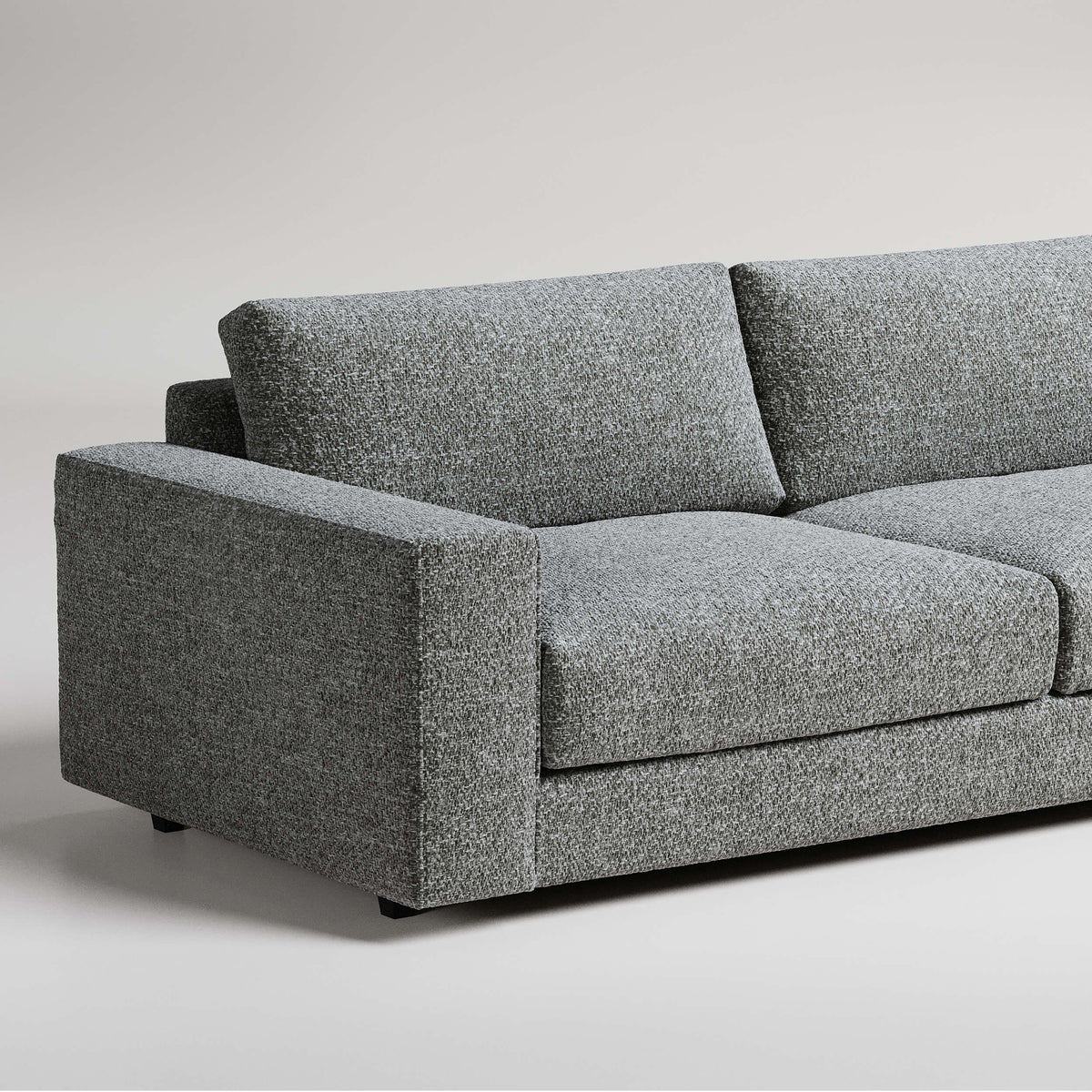 Modern grey tweed sofa with clean lines and square arms photographed against light background
