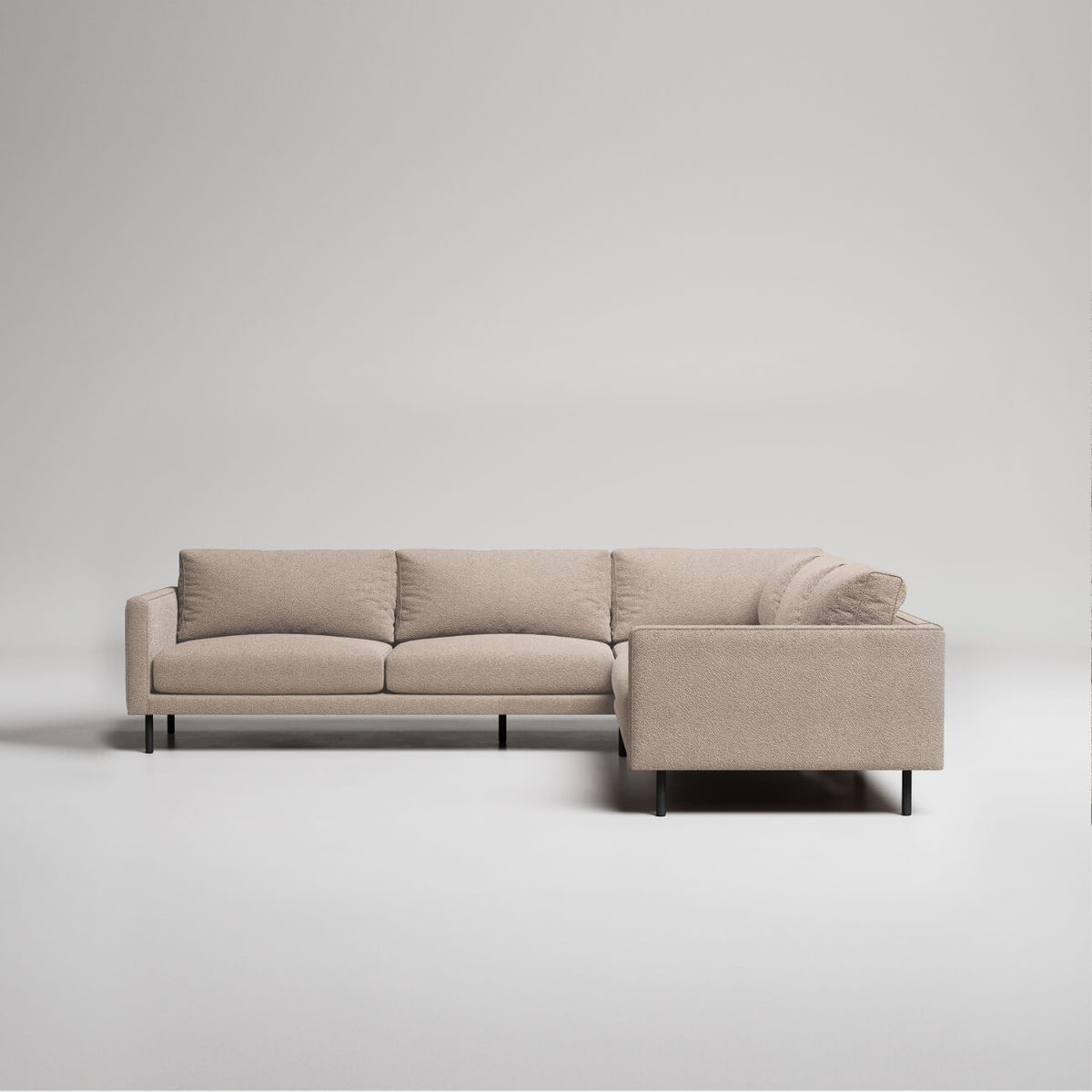 Modern L-shaped sectional sofa in beige textured fabric with black metal legs against white background
