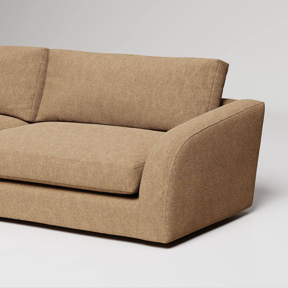 Modern beige linen sofa with curved armrest detail against white background, studio product photography
