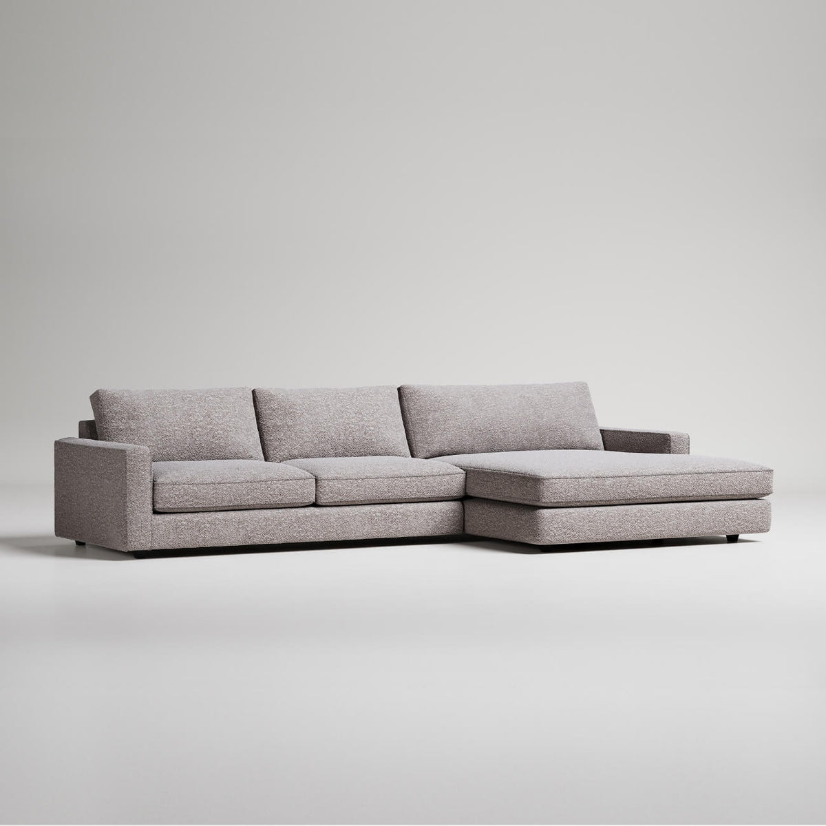 Modern grey L-shaped sectional sofa with chaise lounge on white background, minimalist furniture design
