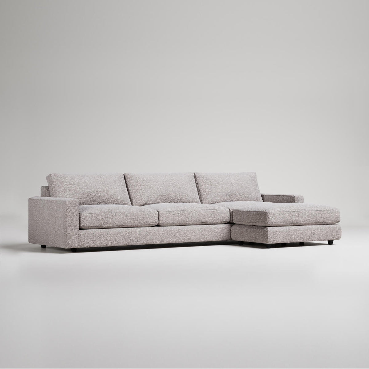 Modern L-shaped sectional sofa in light gray textured fabric with clean lines and chaise lounge extension
